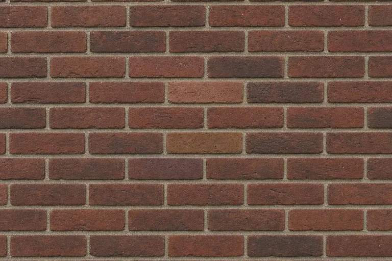 Well-matched red and brown clay bricks aligned in a consistent running bond with evenly spaced mortar joints